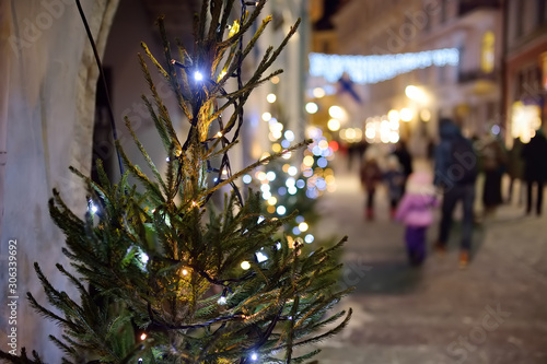 Illuminated fir tree on the street of old town Tallinn in winter evening. Crhistmas holidays in medeival city.