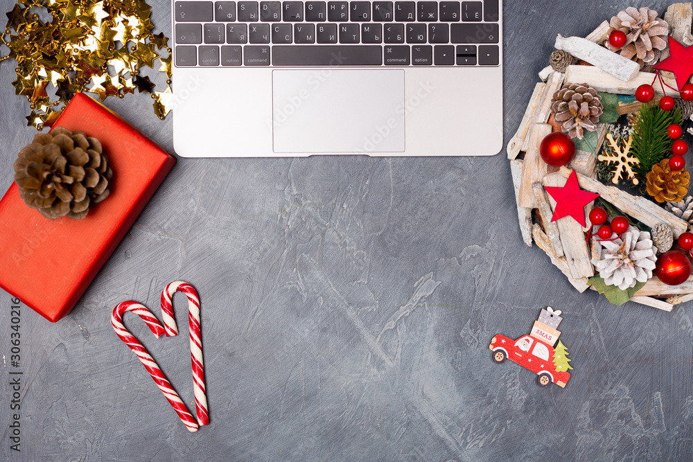Fototapeta premium Christmas New Year creative holiday desktop with laptop, wreath, gift box candy cane blank paper. Copy space. Moke up. 