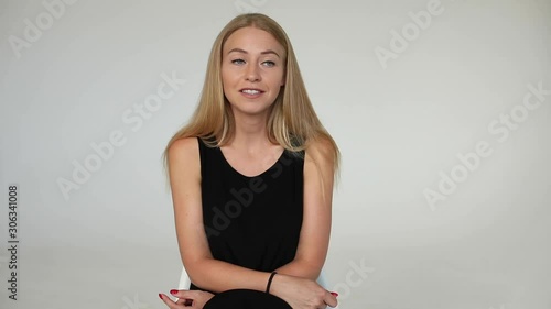 Portrait of adorable young blonde European woman smiling talking looking at camera medium shot. Charming friendly girl speaking having positive emotion isolated at white studio background