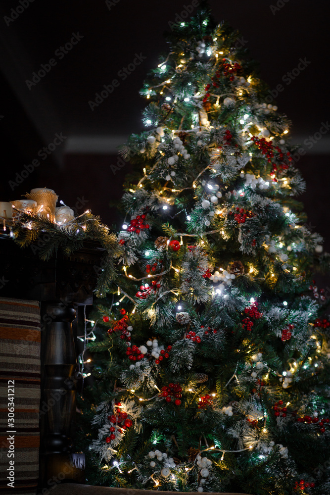 Fototapeta premium Decorated for the new year interior of the house-the General plan. Christmas tree and decorated Studio, lights garlands, decorations, gift boxes in a cozy home.