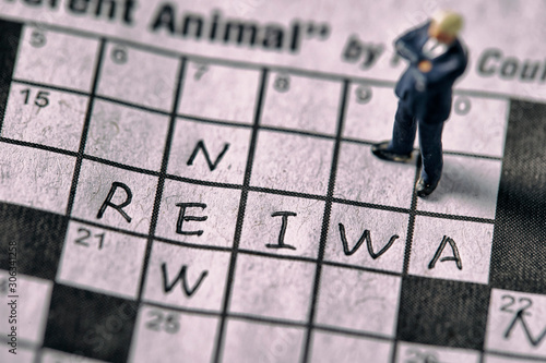 Word New and Reiwa (Japanese era name) on crossword with miniature man photo