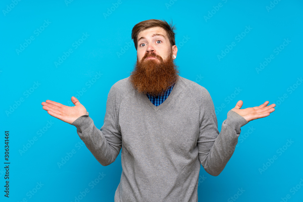 Fototapeta premium Redhead man with long beard over isolated blue background making doubts gesture