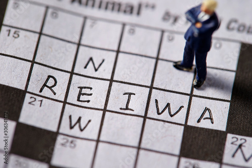 Word New and Reiwa (Japanese era name) on crossword with miniature man photo