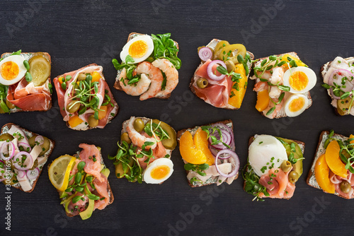 top view of rye bread with smorrebrod sandwiches on grey surface photo