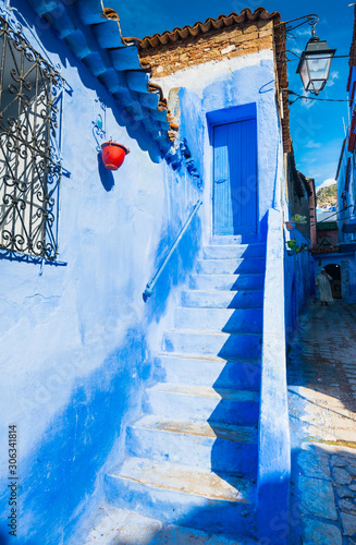 Stairs leading to the blue door in Chefchaouen city in Morocco © leelook