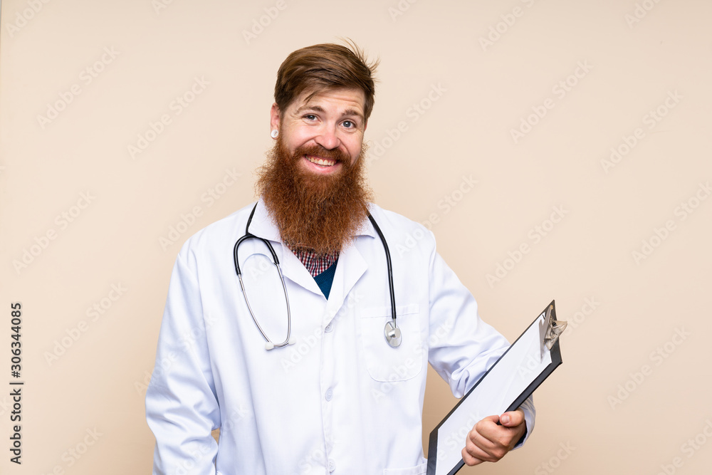 Redhead man with long beard over isolated background with doctor gown and holding a folder Redhead man with long beard over isolated background with doctor gown and holding a folder