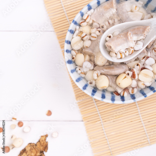 Tasty Four Tonics Herb Flavor Soup, Taiwanese traditional food with herbs, pork intestines on white wooden table, close up, flat lay, top view.