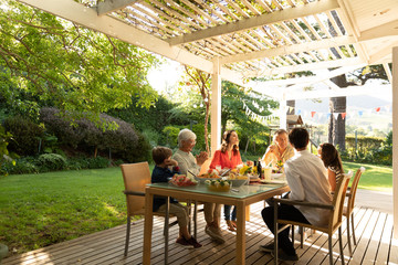 Family eating outside together in summer
