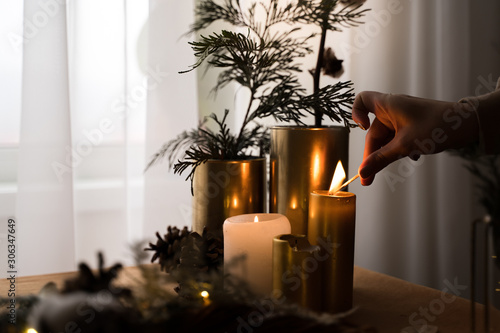 Home hygge with golgen candles and pine trees. Christmas time. Lifestyle cozy home photo