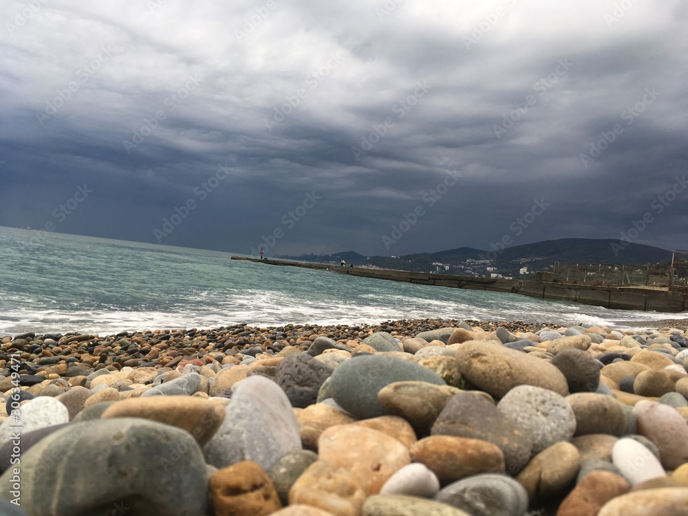 Sea wave on a rocky beach  with clouds