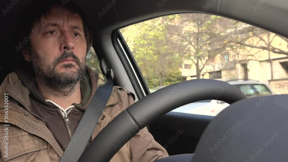 Man driving car through urban surrounding Man driving car through urban surrounding