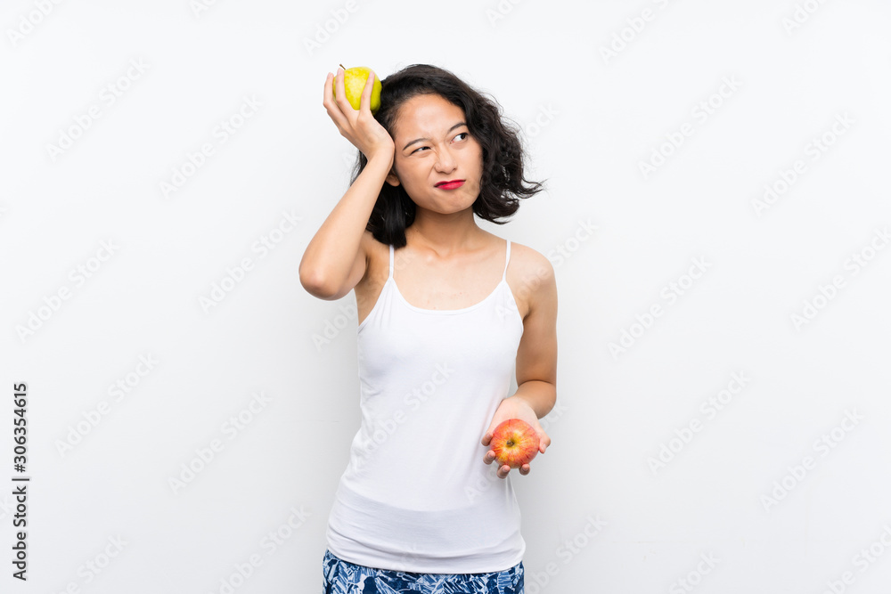Asian young woman with an apple over isolated white background Asian young woman with an apple over isolated white background