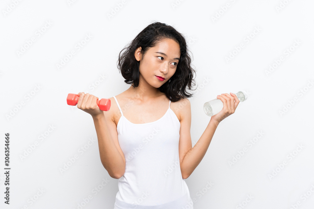Young Asian girl making weightlifting and with a bottle of water Young Asian girl making weightlifting and with a bottle of water