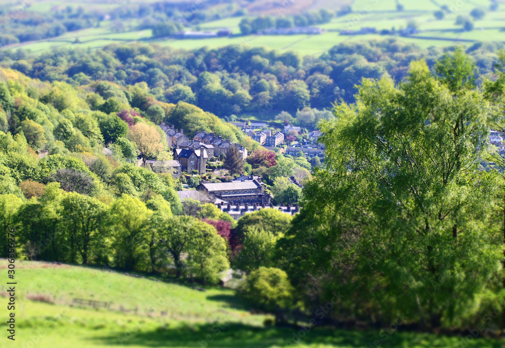 tilt and shift effect photo of the town of hebden bridge in west yorkshire with blurred fields and trees surrounding the town