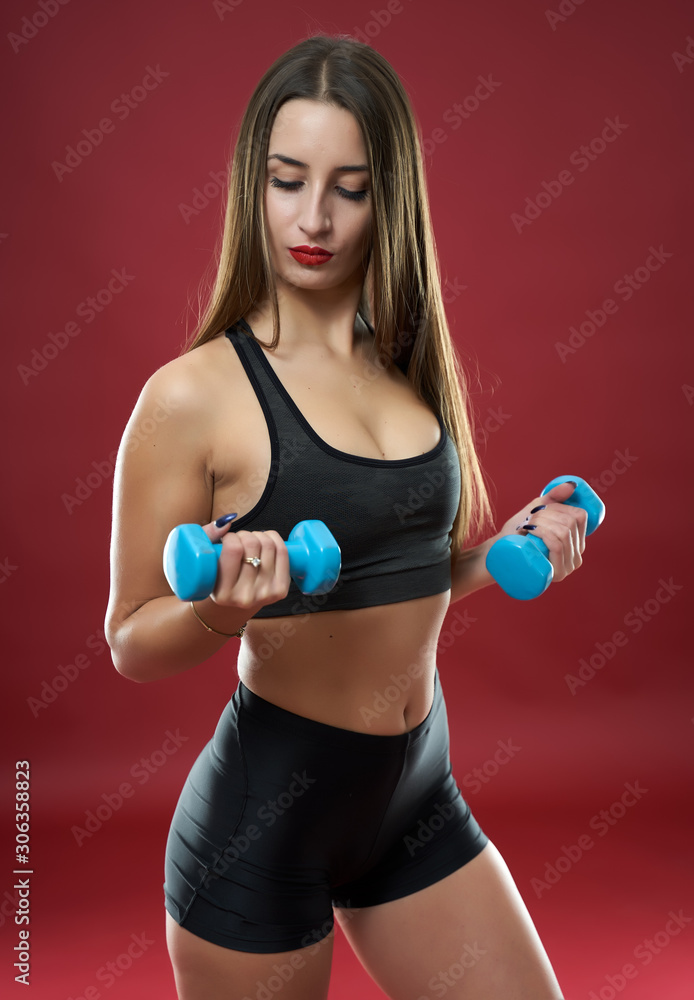 Fitness model doing workout on red background Fitness model doing workout on red background