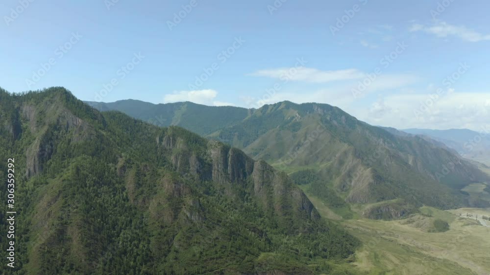Aerial Drone View: Flight over pine tree forest and river in sunset soft light. Mountain range in background. Nature, travel, holidays. Camera go up. 4K motion Aerial Drone View: Flight over pine tree forest and river in sunset soft light. Mountain range in background. Nature, travel, holidays. Camera go up. 4K motion