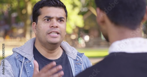 Indian man talks down and deliberately to another man at the park - Slow Motion - shot on RED