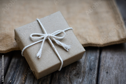 Brown paper gift box tie with rope on old wooden background