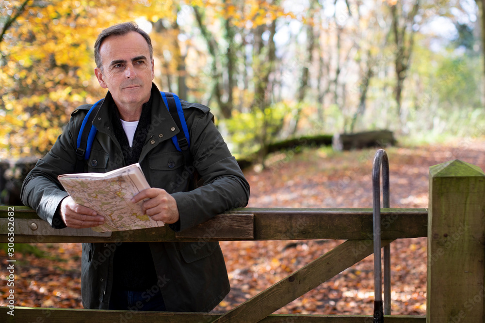 Active Mature Man With Map Walking Through Autumn Woodland In Slow Motion Active Mature Man With Map Walking Through Autumn Woodland In Slow Motion