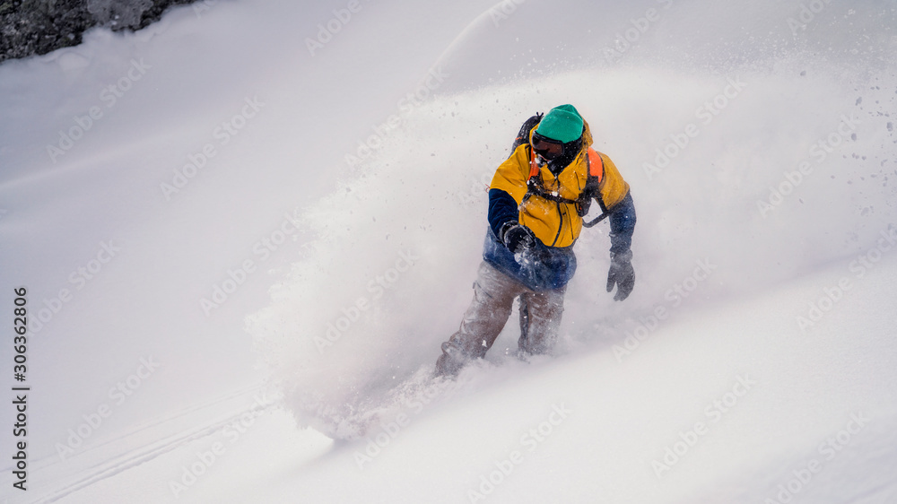 Snowboarder rides on powder a lot of snow Snowboarder rides on powder a lot of snow