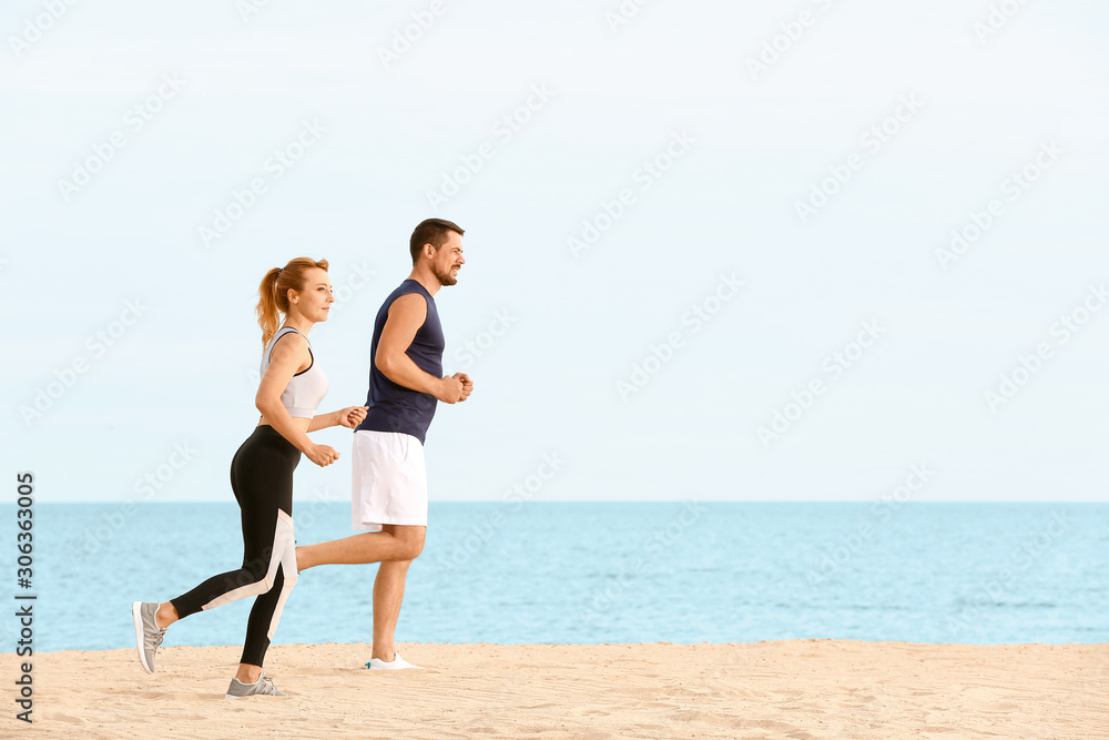 Sporty couple running at sea resort