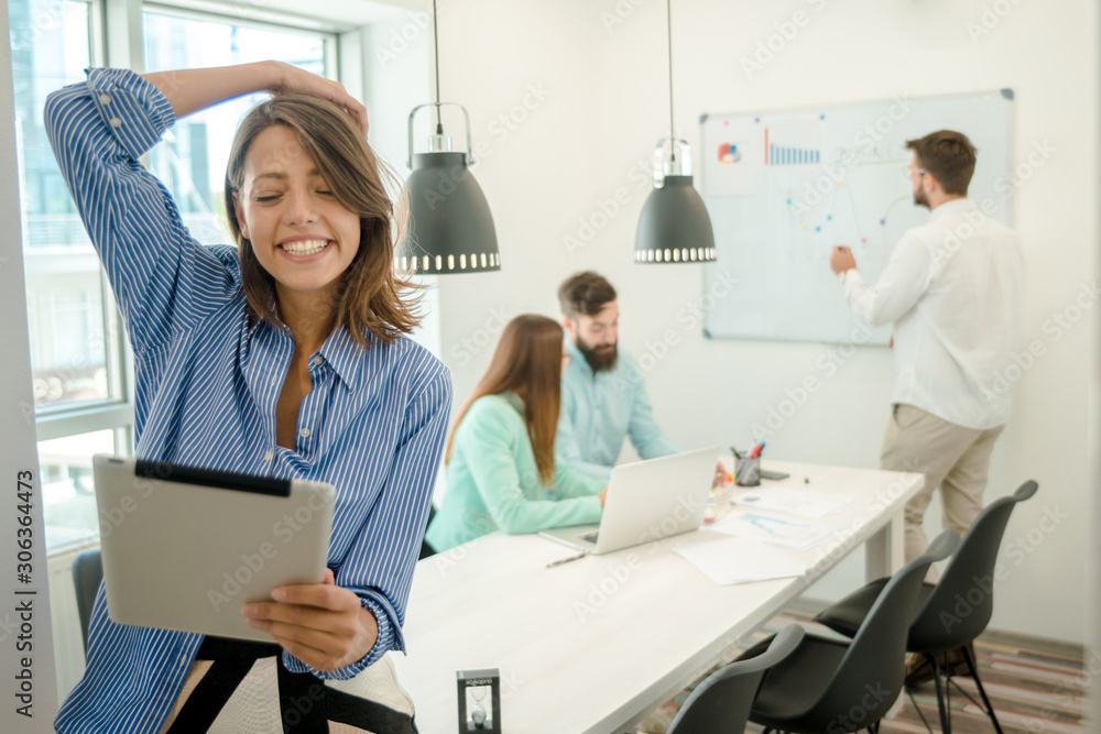 Young woman using tablet. In modern office team people work on new project Young woman using tablet. In modern office team people work on new project
