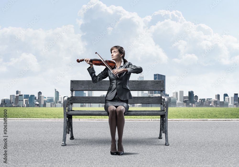 Young woman with violin sitting on wooden bench Young woman with violin sitting on wooden bench