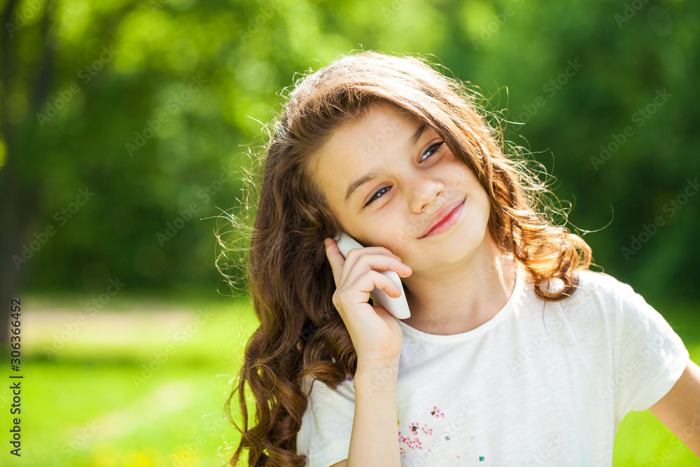 Naklejka premium Portrait of a beautiful young little girl calling by phone