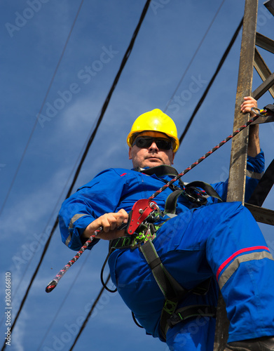 Electrician with safety belt working on lamppost