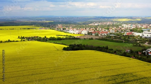 Agricultural area aerial view fields and villages at daytime. Bird eye shot, drone rising up above blooming harvesting rapeseed fields in cloudy day, countryside landscape at spring season  photo