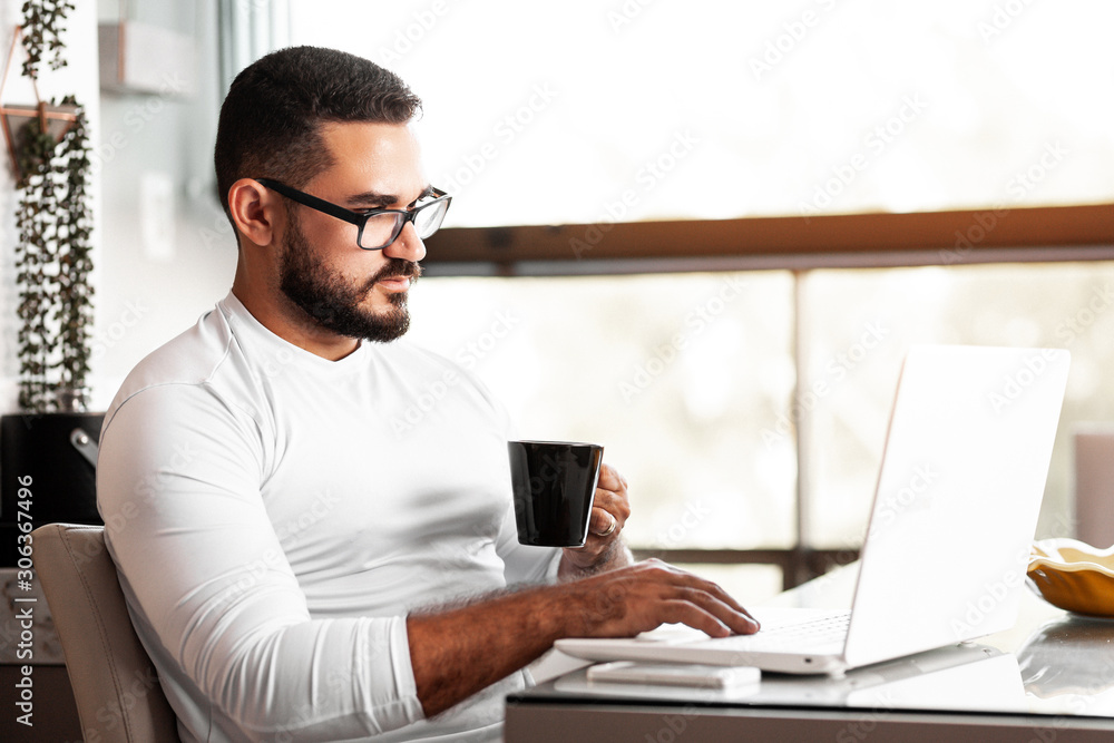 Focused man working on his laptop at home Focused man working on his laptop at home