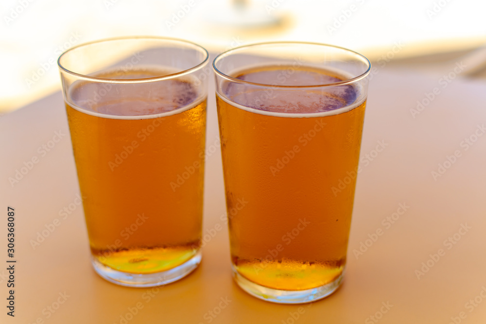 Cold amber color light spanish beer served in glass in outdoor cafe in sunny Andalusia, Spain Cold amber color light spanish beer served in glass in outdoor cafe in sunny Andalusia, Spain