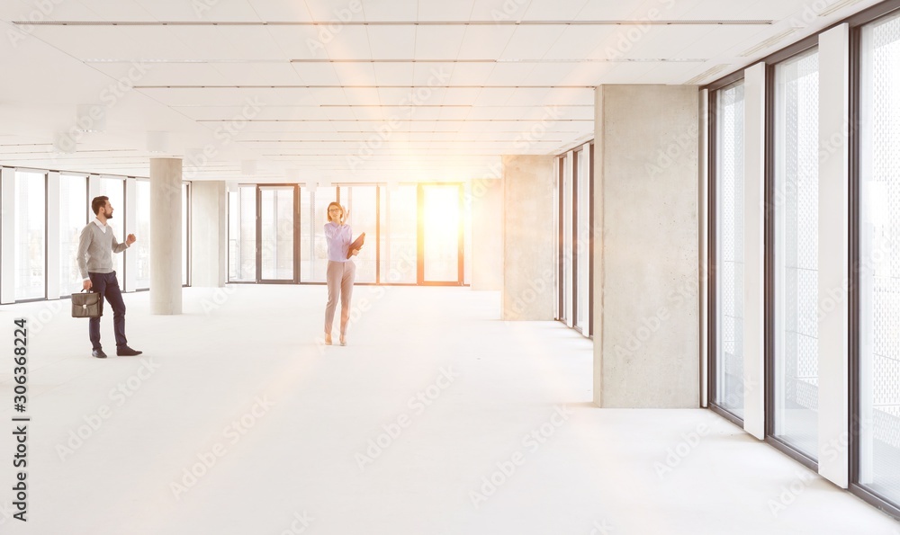 Businessman and woman planning in new empty workspace Businessman and woman planning in new empty workspace