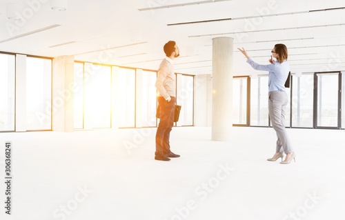 Professionals analyzing empty workspace in new office