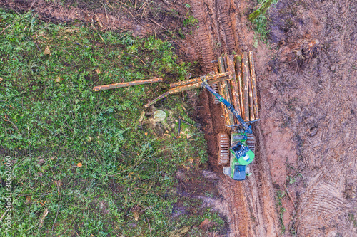 Aerial view of logs being stacked by heavy machinery on a commercial timber site