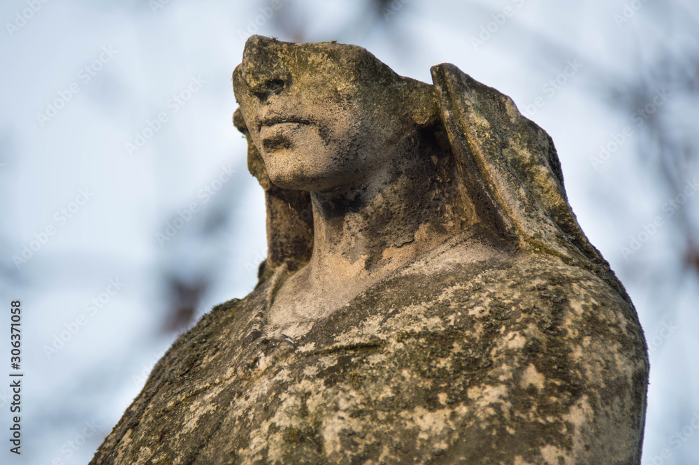 Monument and candles in the cemetery. All Saints Day in Poland. Stone statue. Statue without a face. Monument and candles in the cemetery. All Saints Day in Poland. Stone statue. Statue without a face.