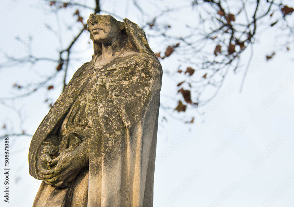Monument and candles in the cemetery. All Saints Day in Poland. Stone statue. Statue without a face. Monument and candles in the cemetery. All Saints Day in Poland. Stone statue. Statue without a face.