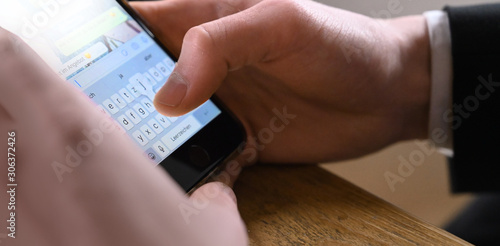 Businessman schreibt eine Nachricht und tippt eine Kommunikation via Chat mit dem Handy cellphone im Büro.
