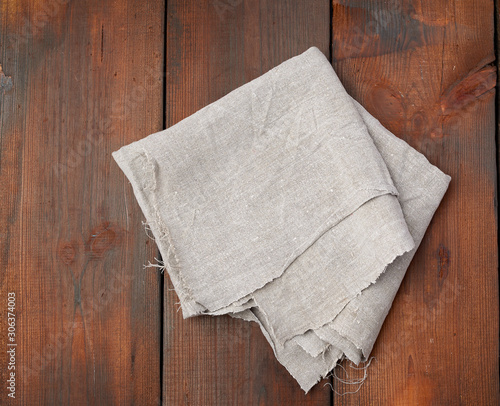 gray linen towel on wooden background, top view