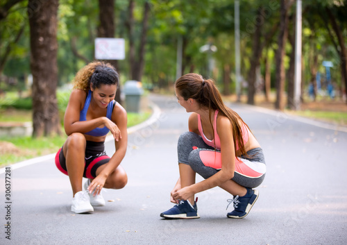 Healthy beautiful sportswoman wearing tracksuit jogging in the park, African american women and Caucasian women