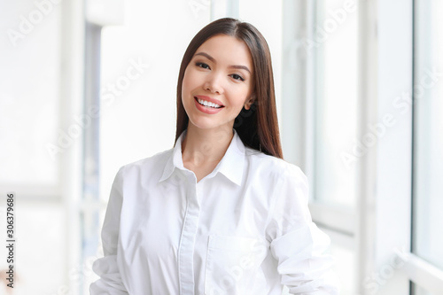 Beautiful Asian businesswoman near window in office