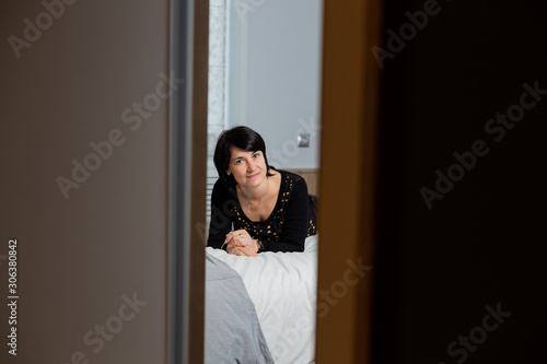 Beautiful woman 50 years old is lying on the bed. Portrait of a woman.