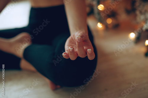 Beautiful woman practices yoga in christmas. 