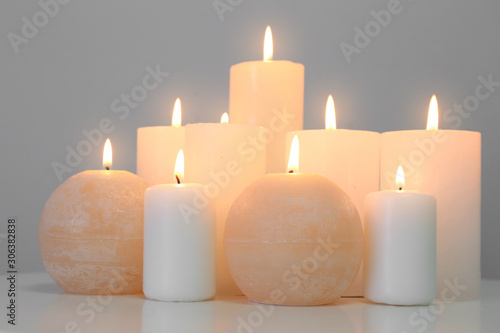 Glowing candles on white table