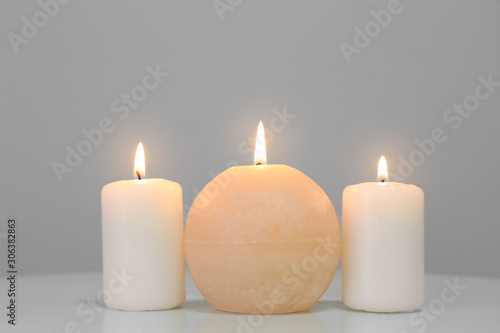 Glowing candles on white table