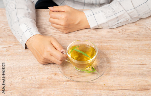 Woman drinking tea made from cannabis leaves ,A cup of hot marijuana tea with buds and leaves.