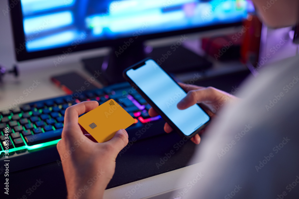 Close Up Of Person With Addiction To Online Gambling Or Shopping Using Credit Card And Mobile Phone Close Up Of Person With Addiction To Online Gambling Or Shopping Using Credit Card And Mobile Phone