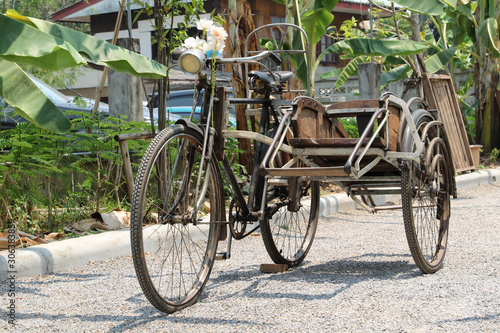 Vintage old black tricycle decorated in the park.