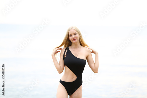 Fashion and Glamour Portrait of pretty beautiful fashion woman in black bikini posing in summer near the sea and sunset sky in evening,tropic island girl on vacation © FotoArtist