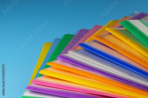 Multi-colored plastic folders for paper on a blue background.